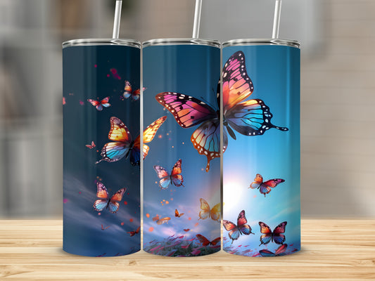 Three tumblers with colorful butterflies against a sunset sky.