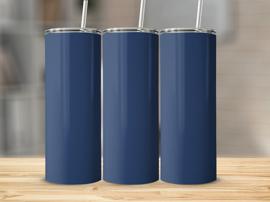 Three navy blue tumblers with white straws stand on a wooden surface.