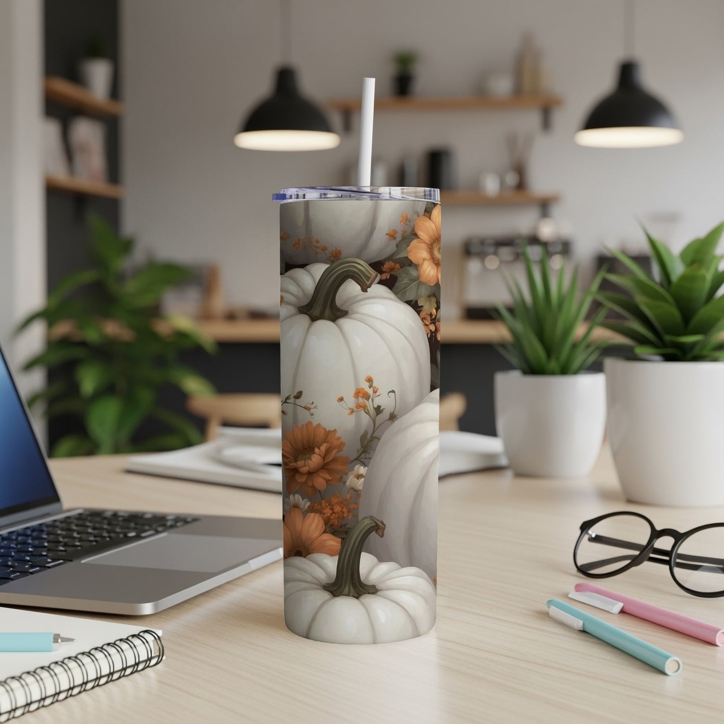 White pumpkins and fall flowers pattern on a tall, skinny tumbler with straw.