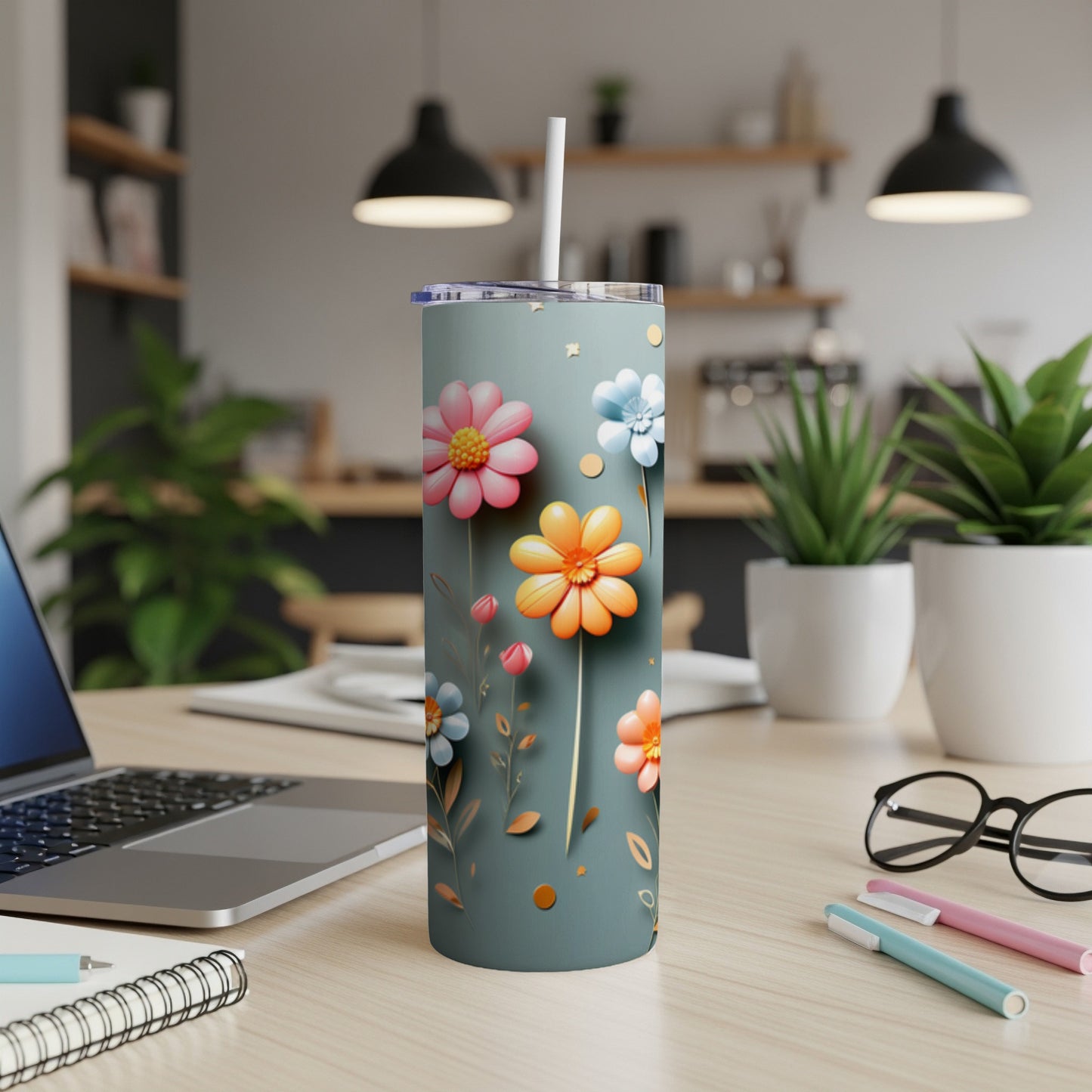 Floral patterned tumbler with straw on a desk.