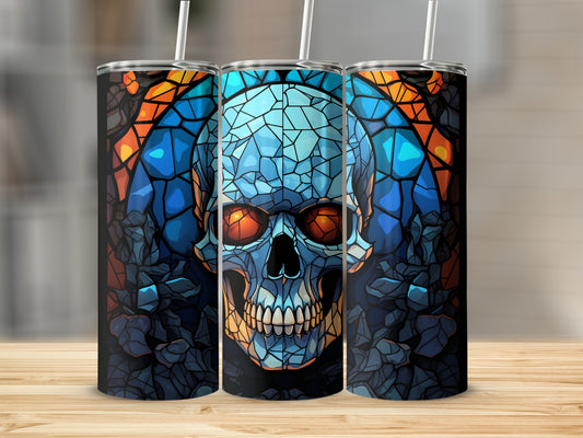 Blue and orange mosaic skull design on three tumblers against a blurred background.