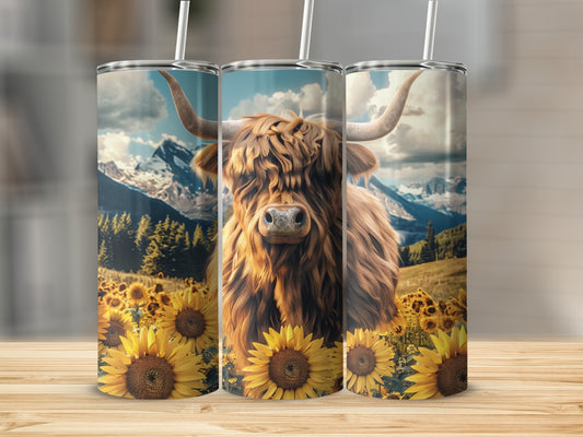 Highland cow with sunflowers in front of mountains on a tumbler.