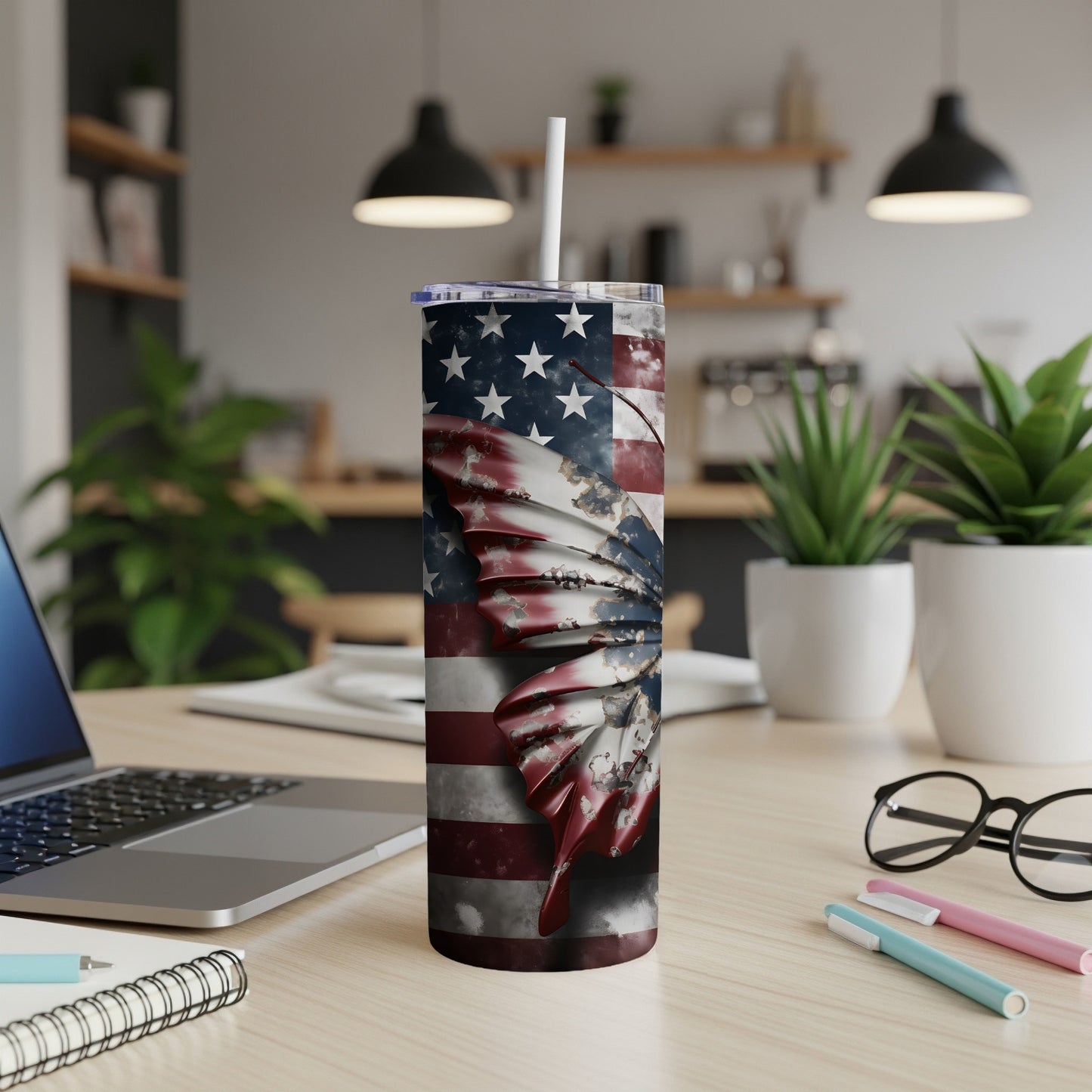 USA flag butterfly tumbler with straw on a desk.