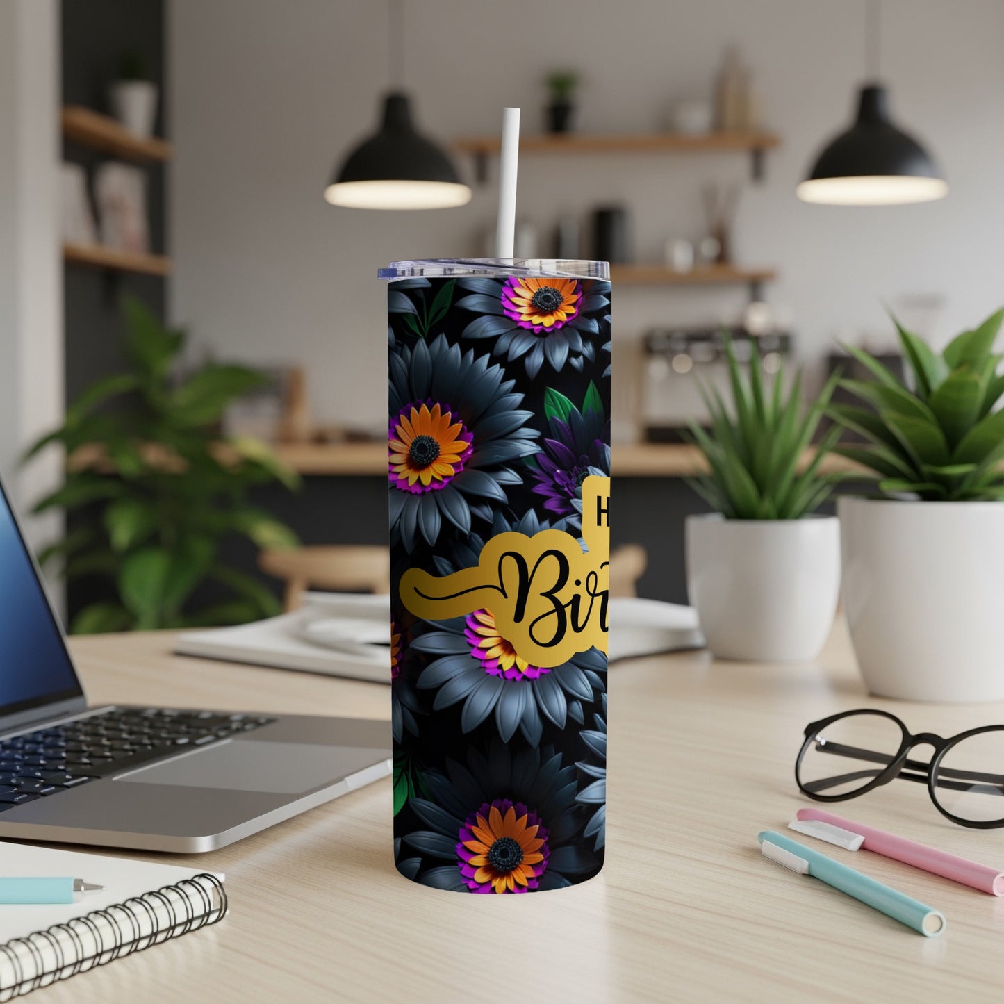 Floral tumbler with "Happy Birthday" text on a desk.