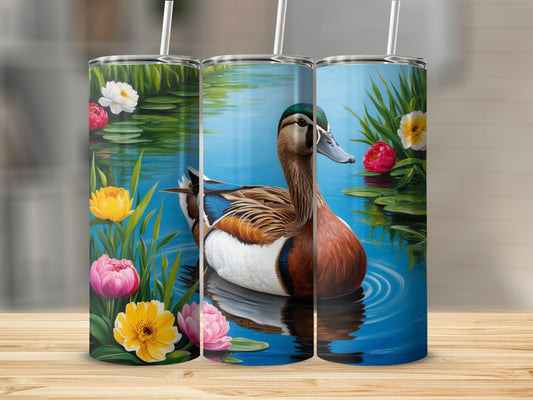 Mallard duck on water with colorful flowers and lily pads.