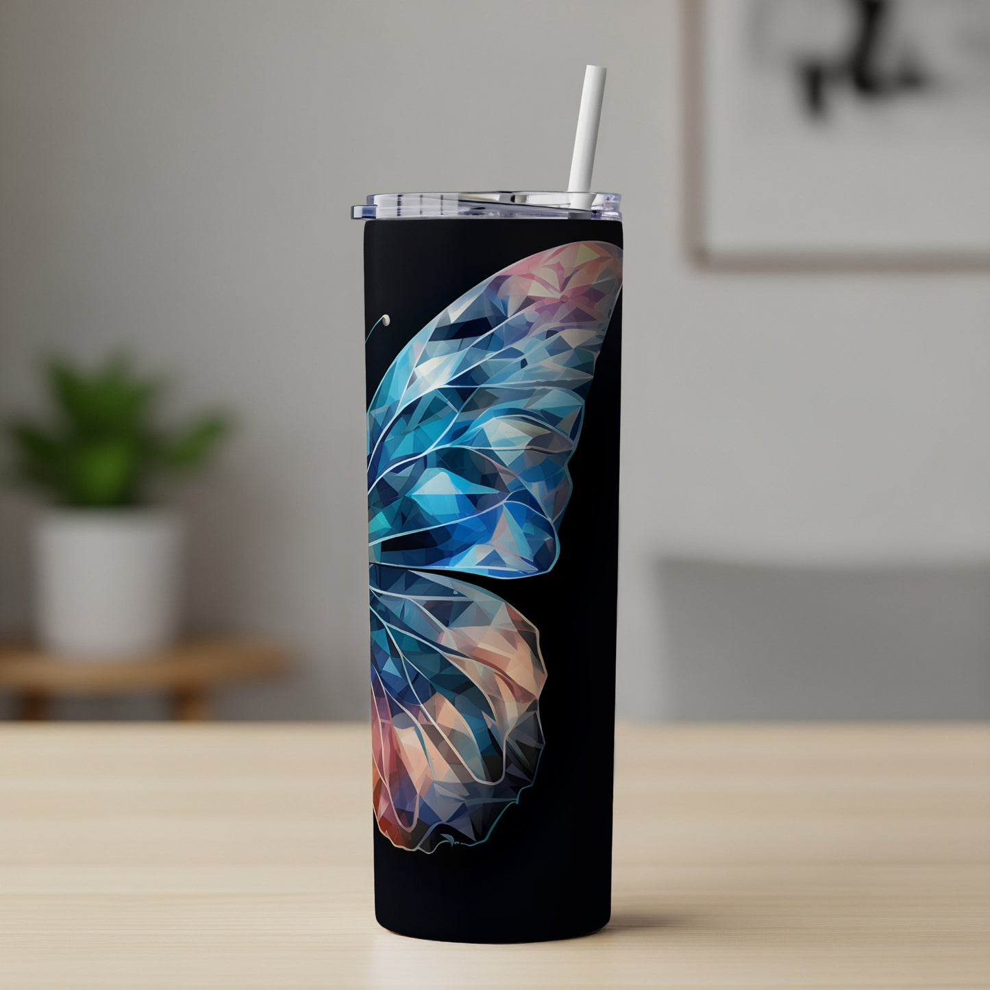 Black tumbler with a geometric butterfly wing design and white straw.