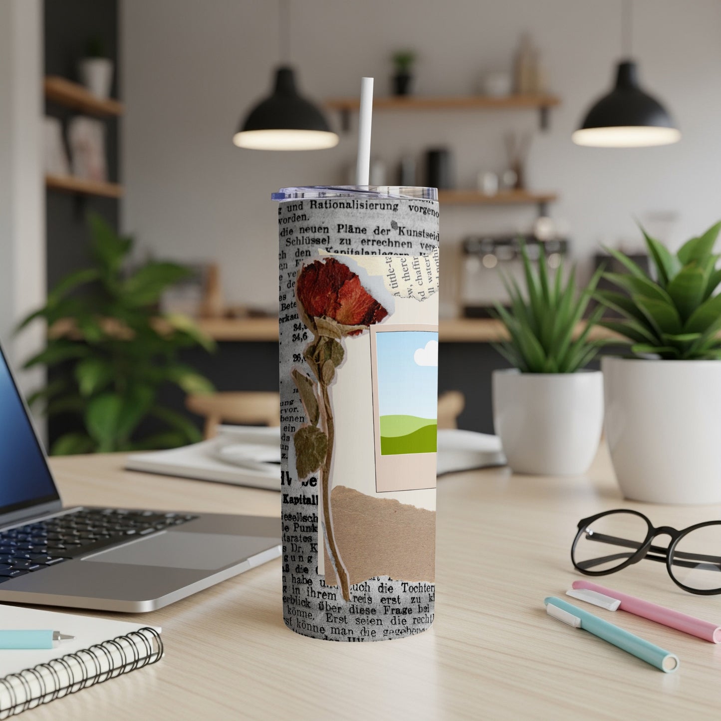 Tumbler with dried rose, torn paper, and landscape photo design.