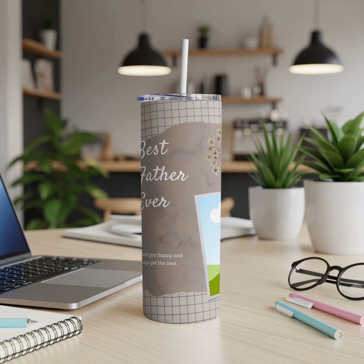 Tumbler with "Best Father Ever" text and a picture frame on a desk.
