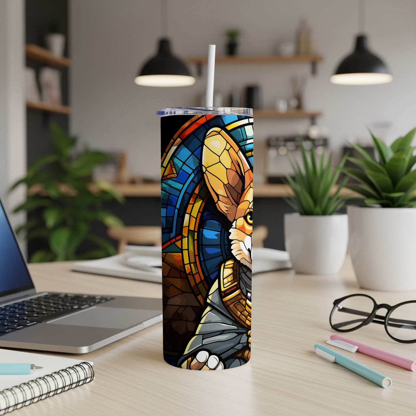 Tumbler with stained glass fox design and white straw on a desk.
