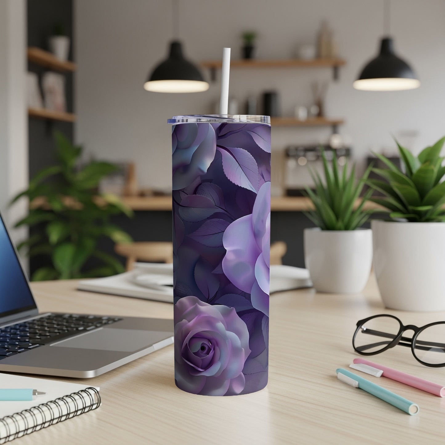 Purple floral tumbler with white straw on a desk with a laptop.