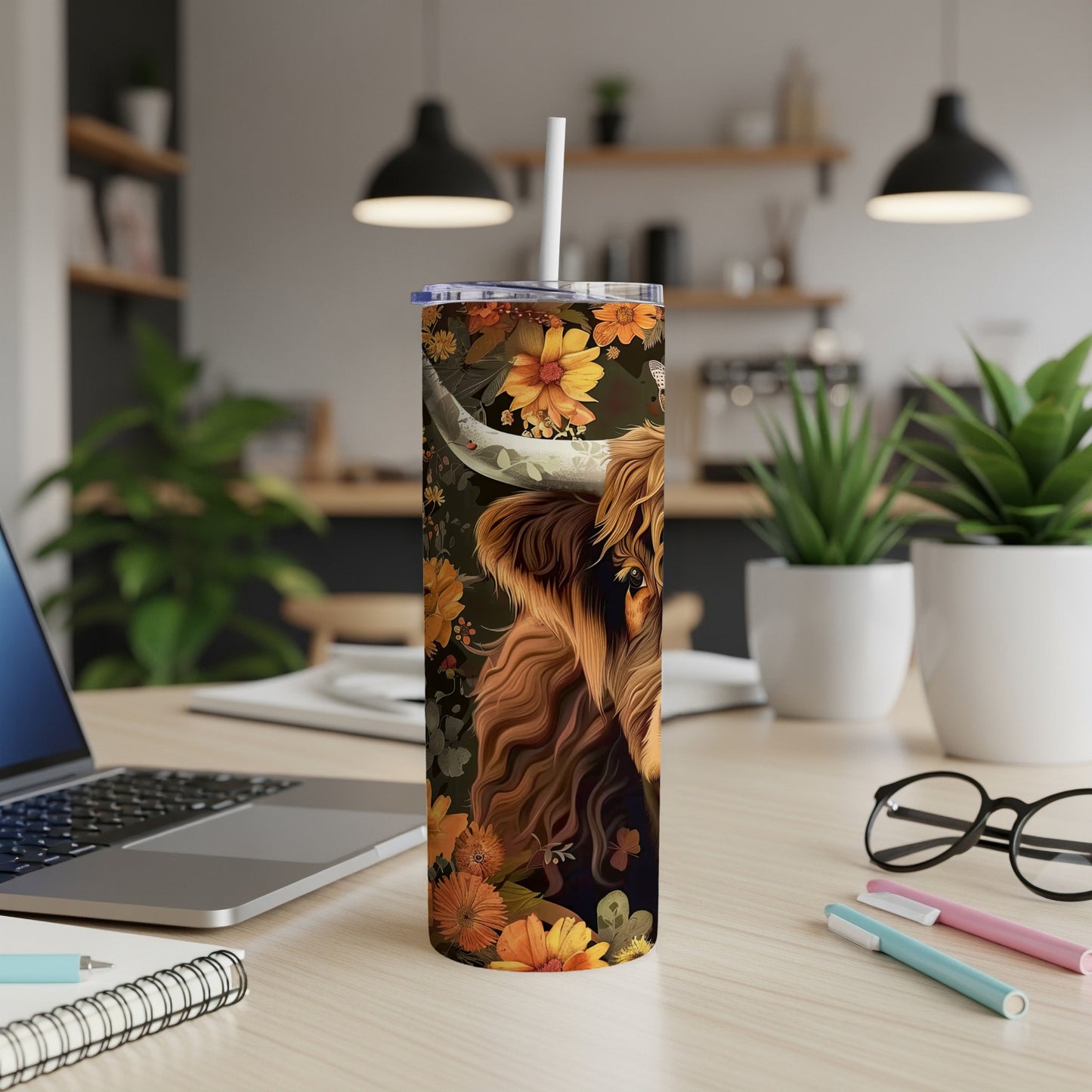 Highland cow with floral accents on a white skinny tumbler with straw.