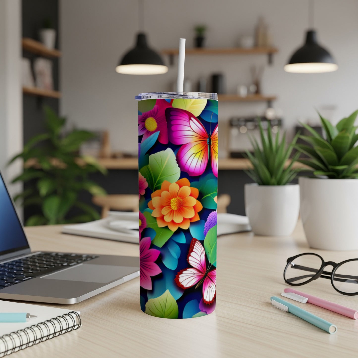 Tumbler with colorful butterflies and floral design on desk.