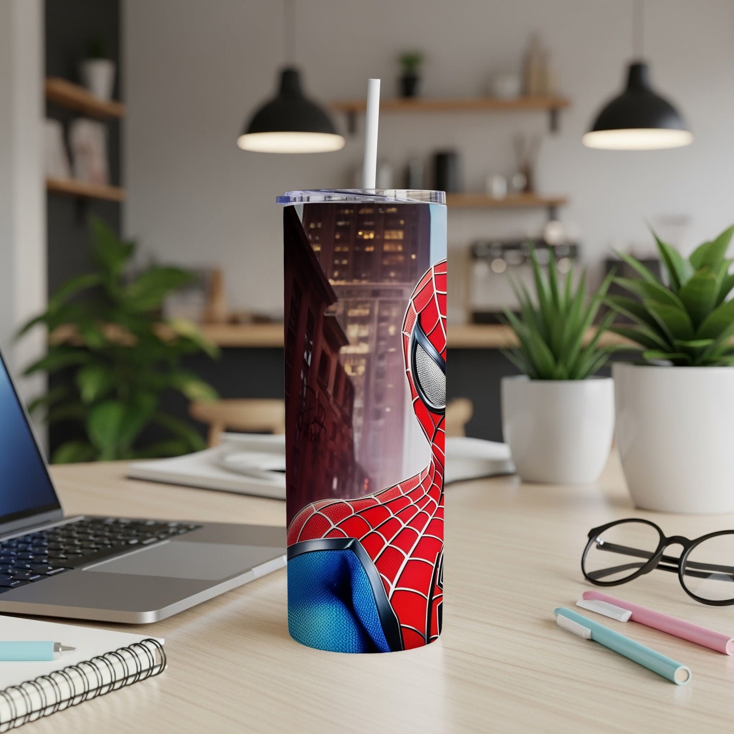 Spiderman tumbler on a desk with a laptop and office supplies.