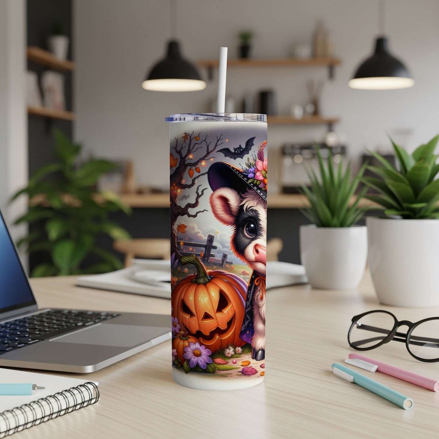 Cute cow in Halloween costume with pumpkin and bats on a tumbler.