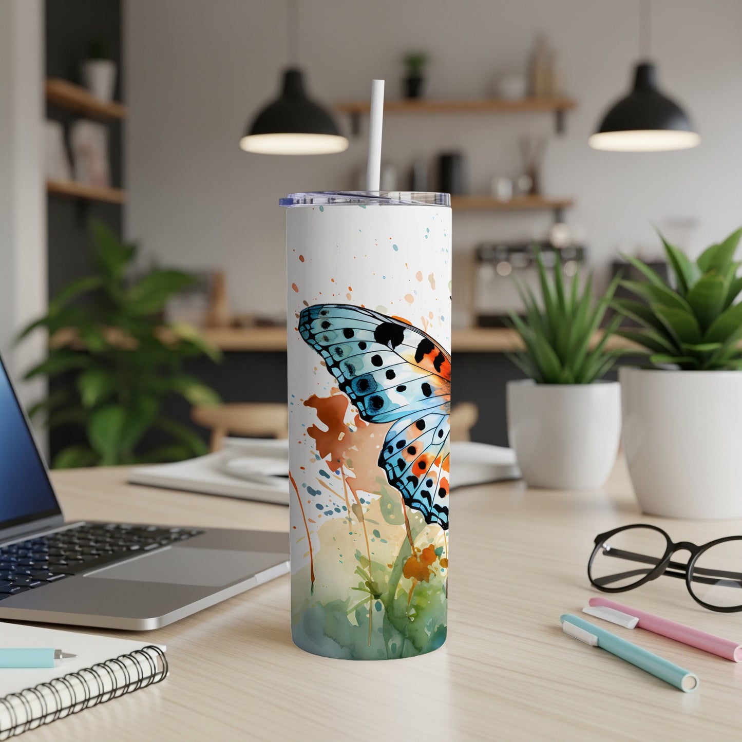 White tumbler with blue butterfly and watercolor floral design.