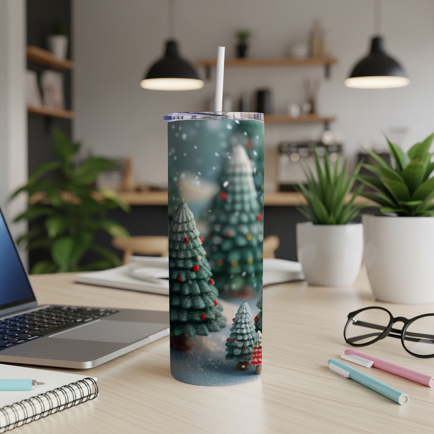 Christmas trees on a tumbler with a straw, on a desk.
