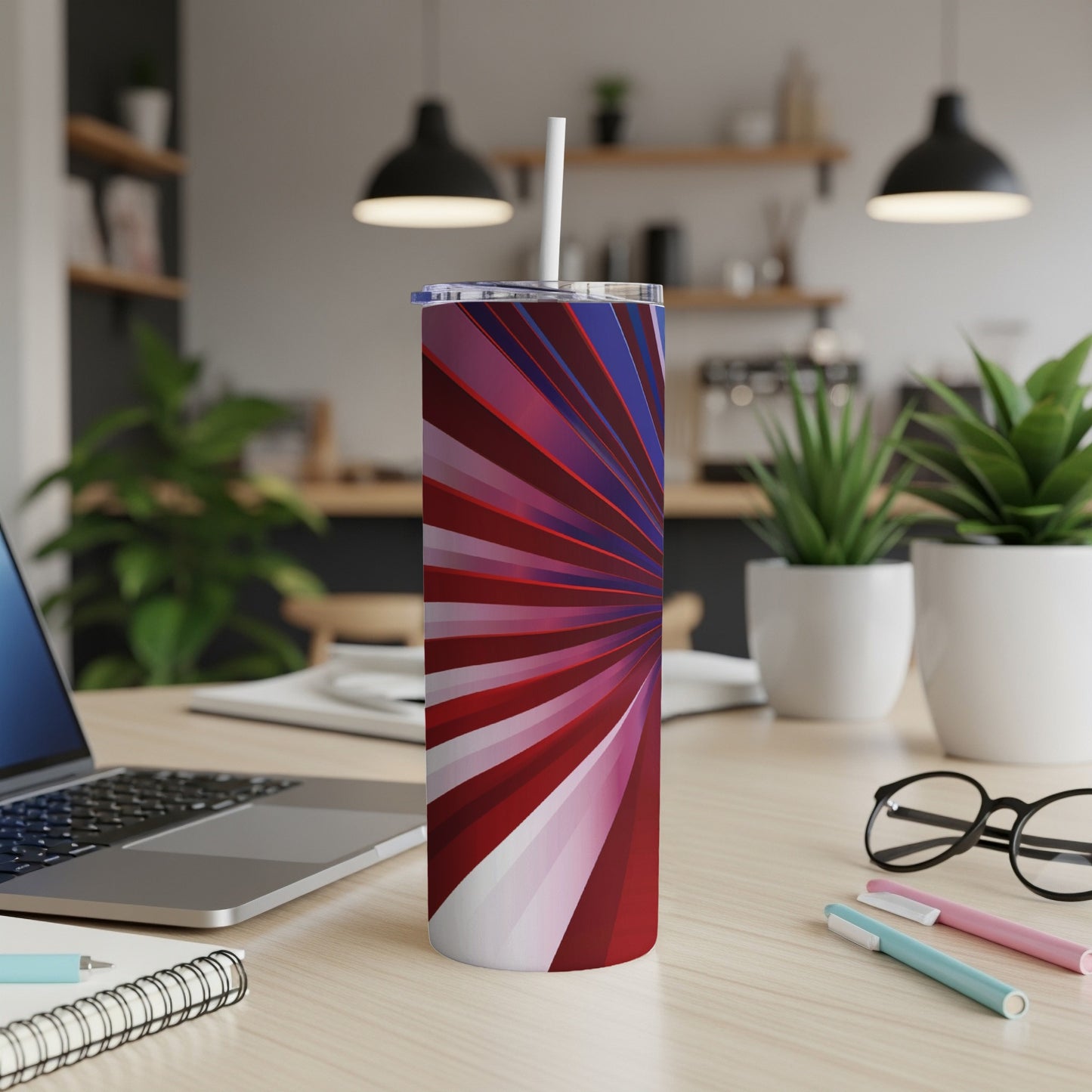 Red and blue abstract sunburst pattern on a stainless steel tumbler with a straw.