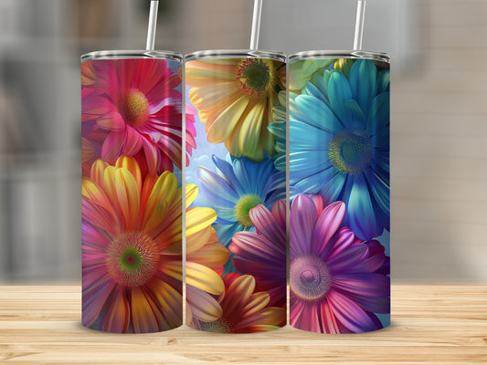 Three colorful flower patterned tumblers with straws displayed on a wooden surface.
