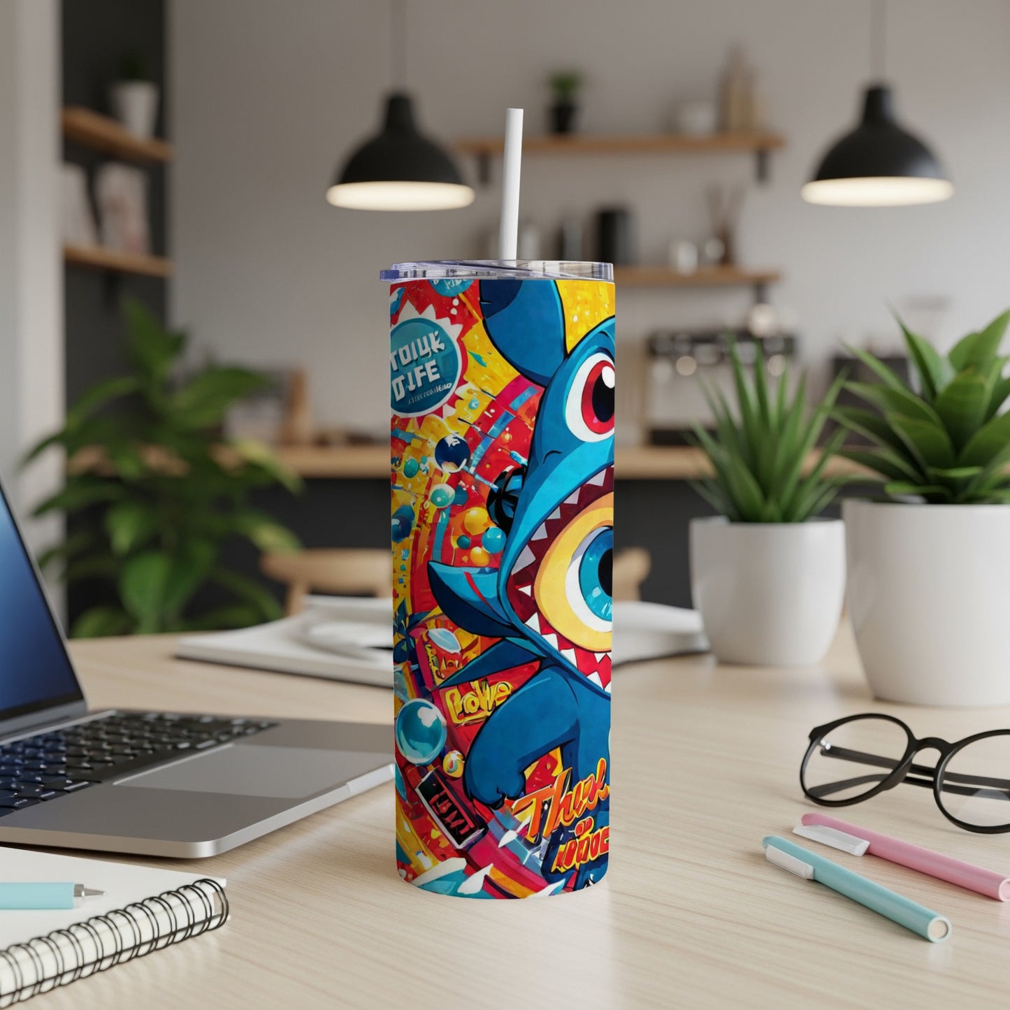 Blue Stitch character on a colorful tumbler with straw, on a desk.