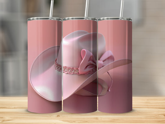 Pink cowboy hat with a bow and gems on a pink tumbler.