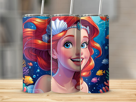 Mermaid with red hair and blue eyes smiles surrounded by fish and coral.