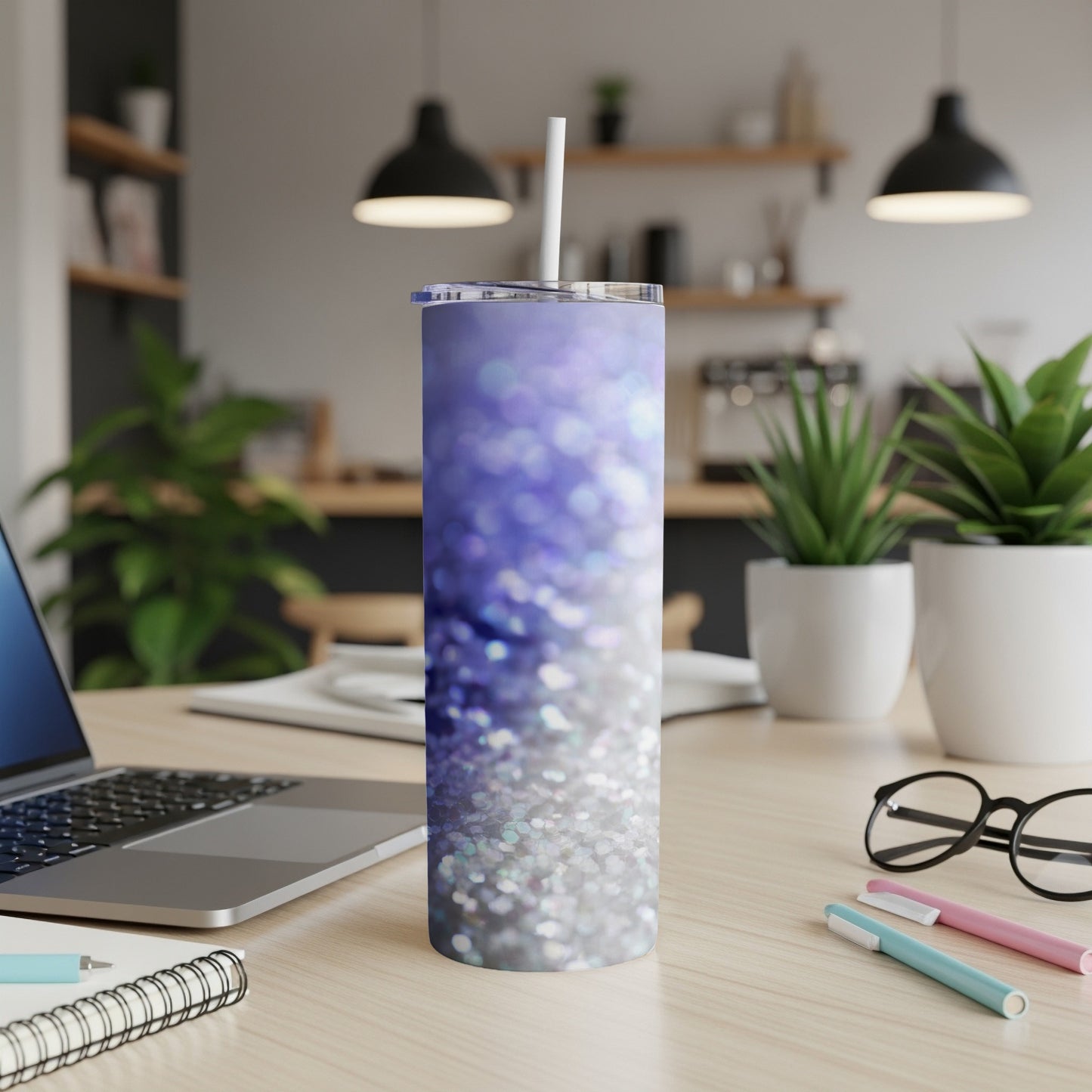 Glittering purple and silver gradient tumbler with straw on desk.