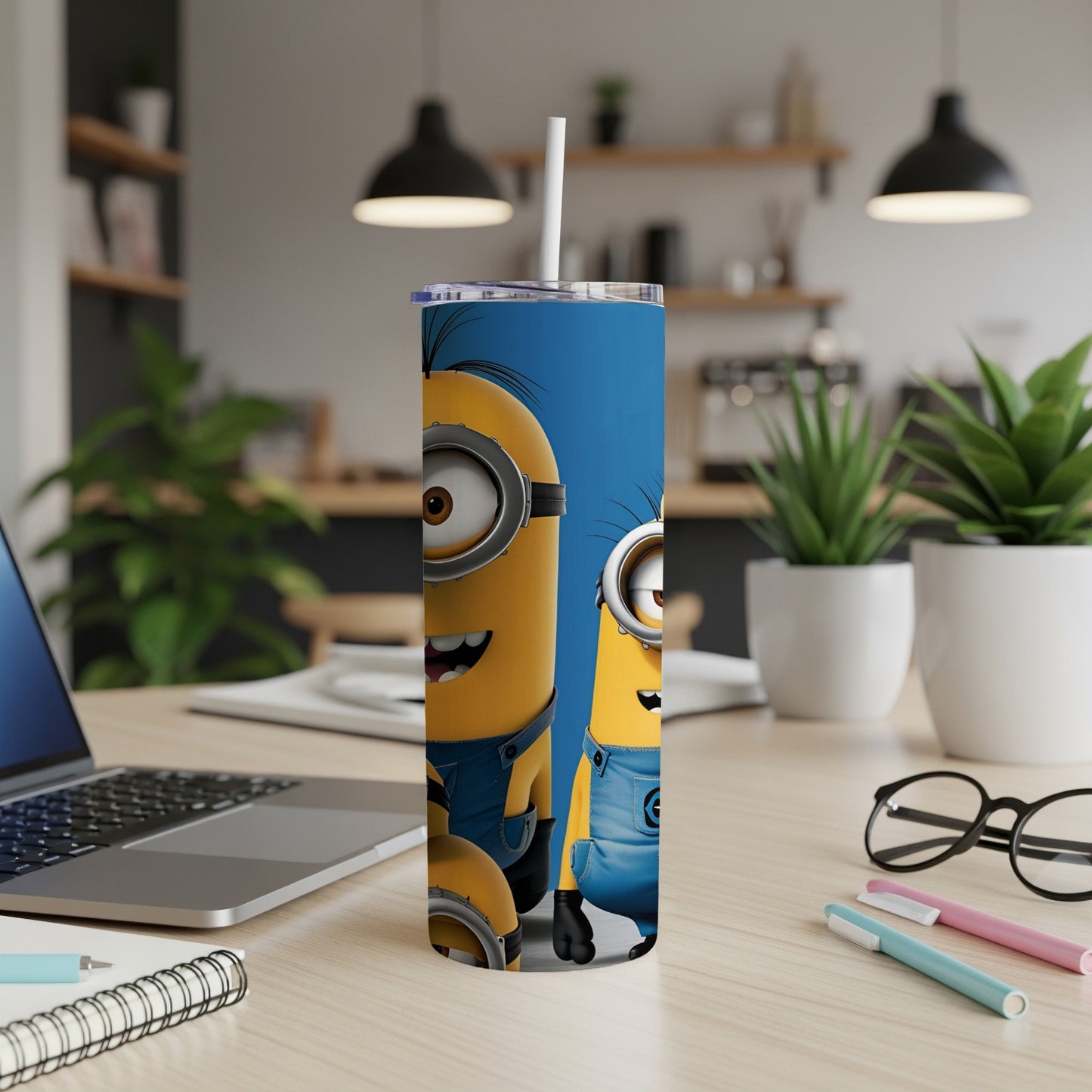 Minions characters on a blue skinny tumbler with a straw.