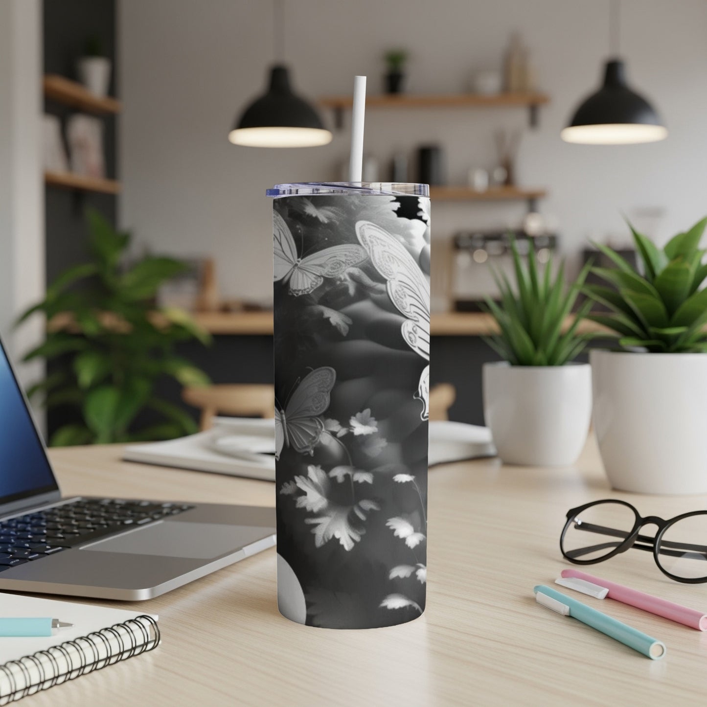 Black and white tumbler with swirling butterflies and leaves design.