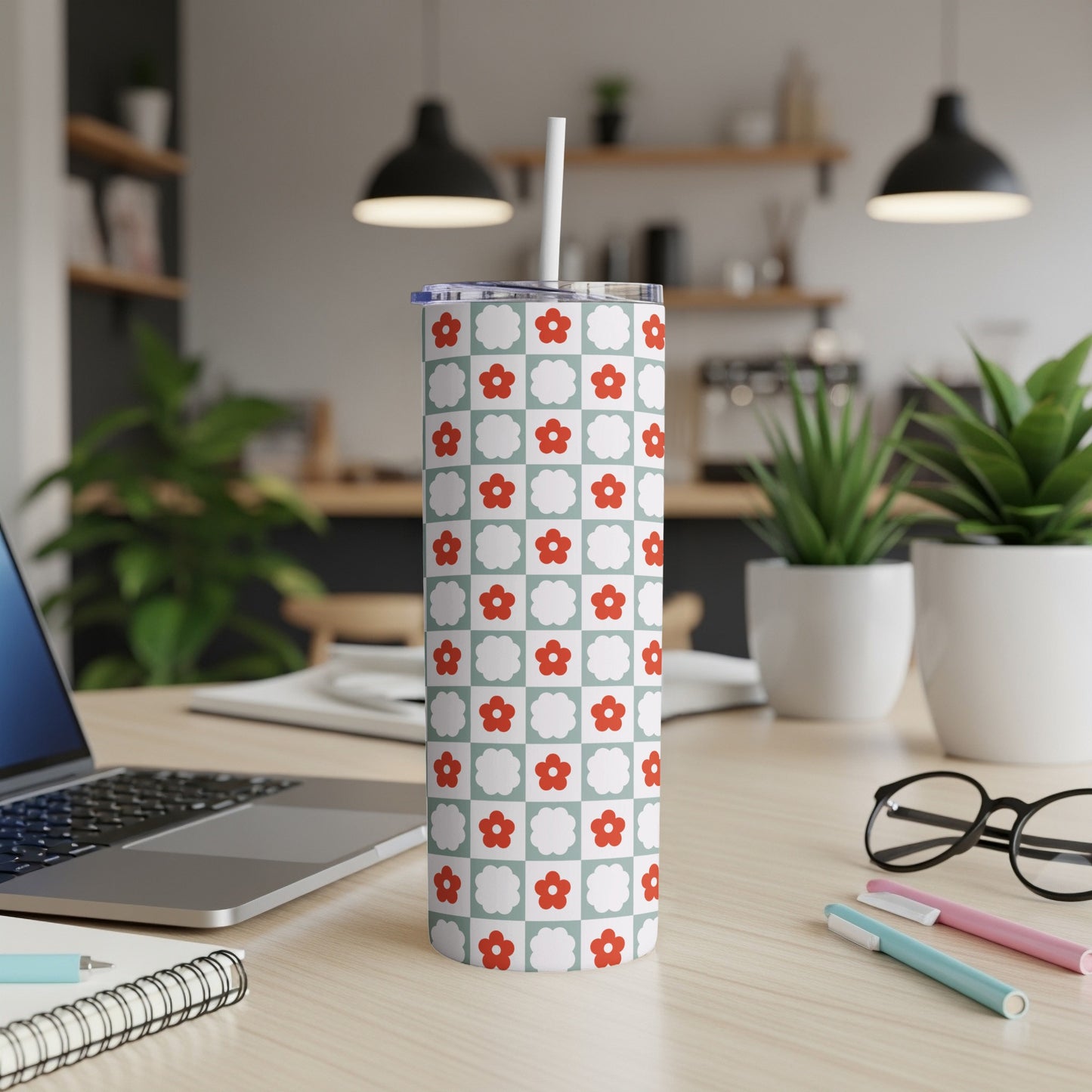 White tumbler with red and blue flower pattern on a light blue background.