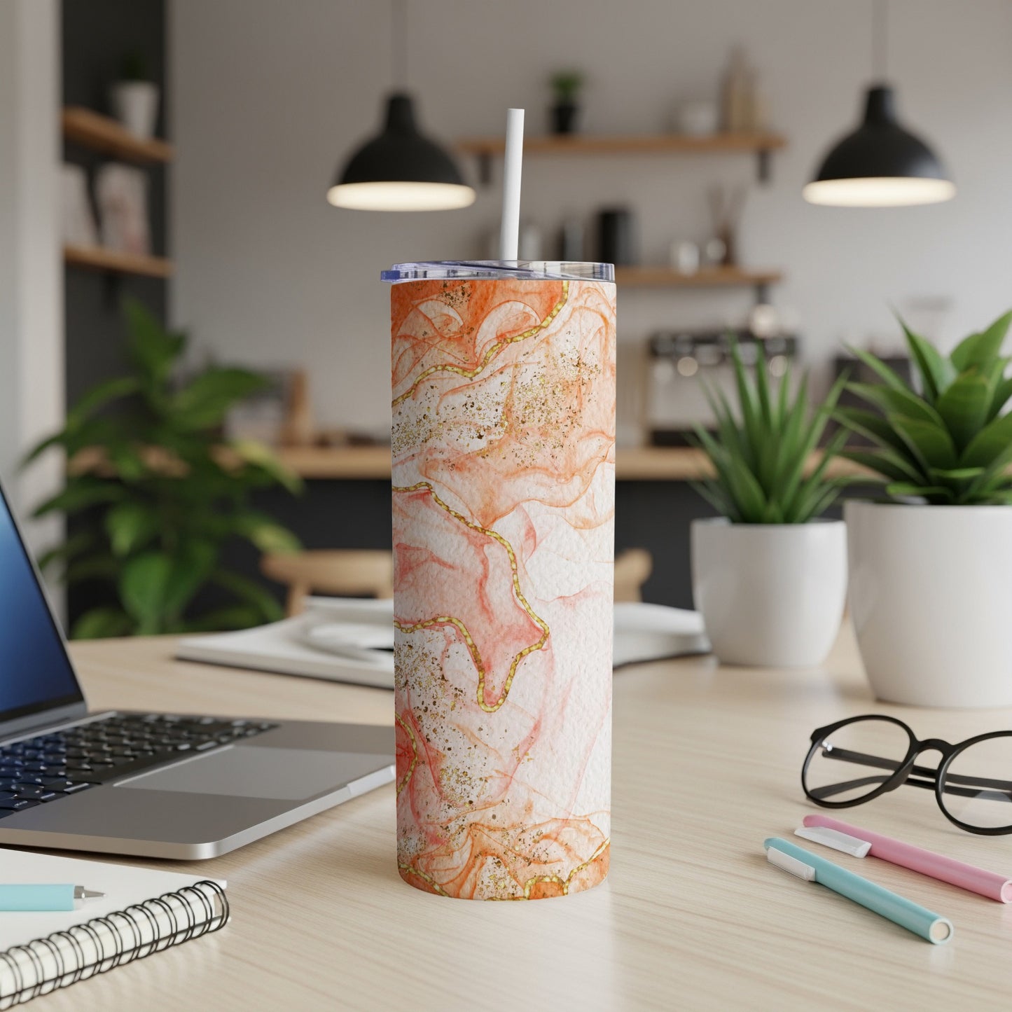 Orange marble skinny tumbler with gold glitter accents and white lid.