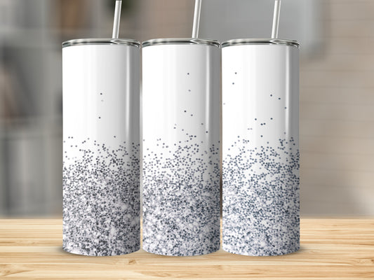 Three white tumblers with silver glitter at the bottom on a wooden surface.