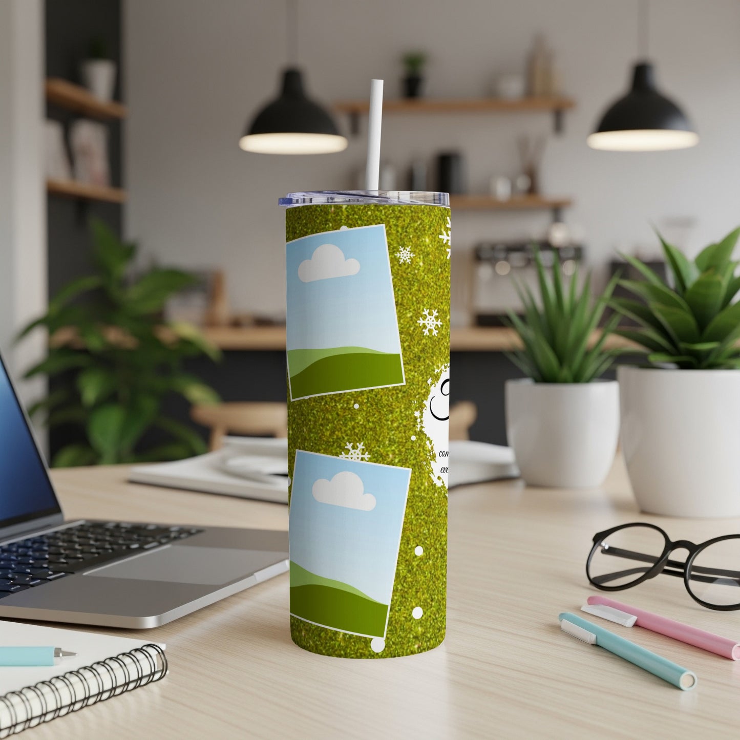 Green glitter tumbler with photo frames, snowflakes, and text, on a desk.