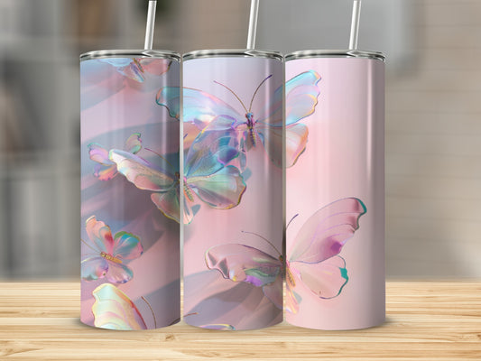 Three iridescent butterfly tumblers with straws on a wooden surface.