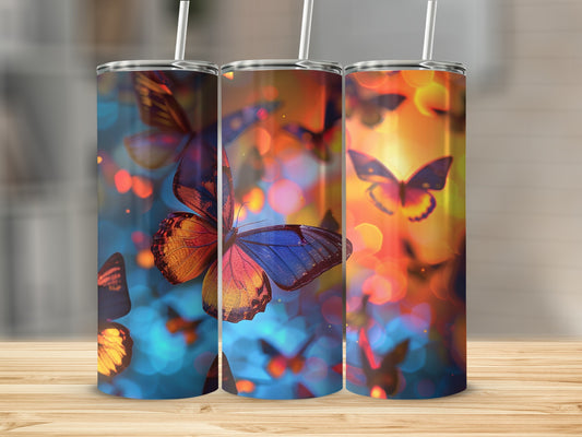Three tumblers with colorful butterfly designs and bokeh background.