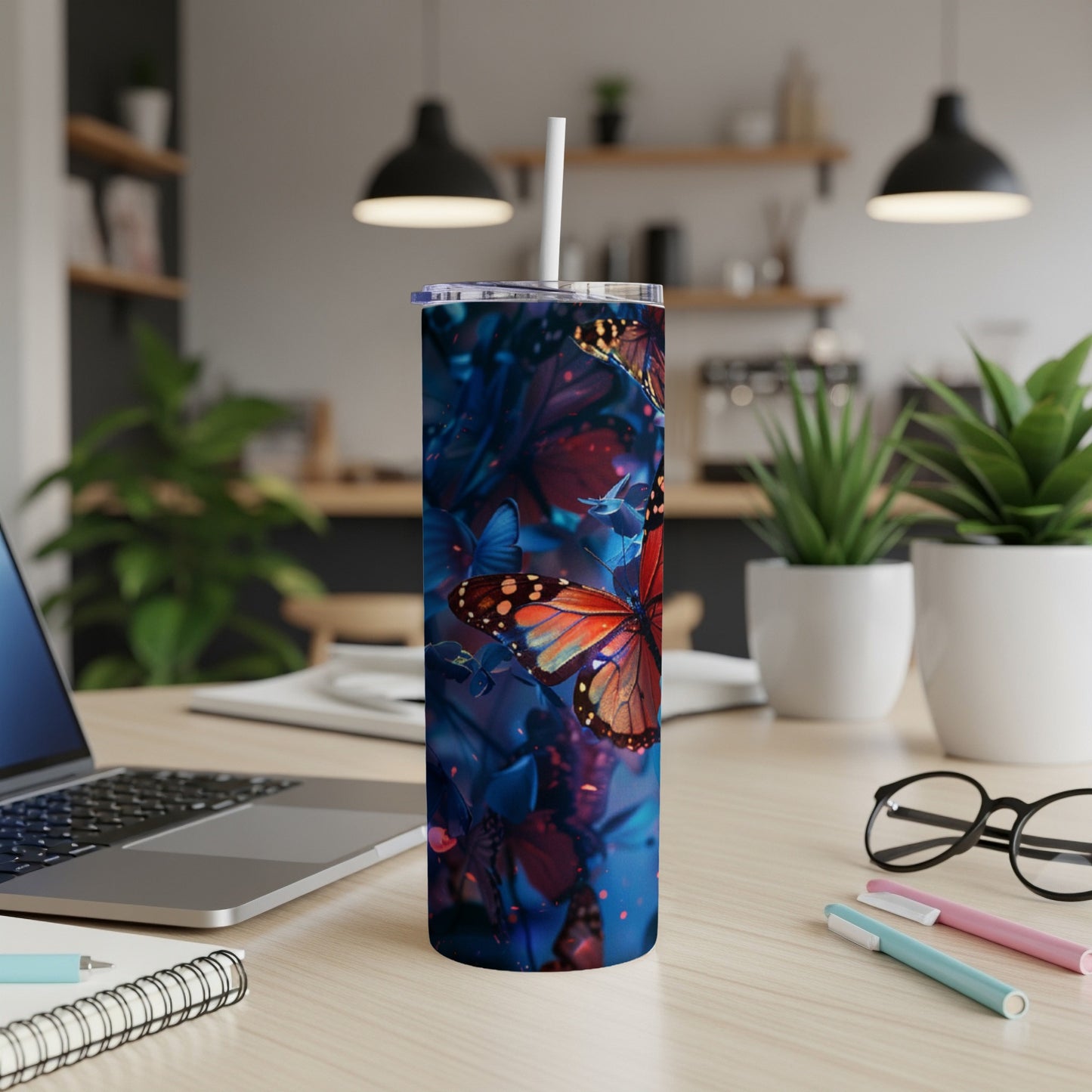 Tumbler with orange and blue butterflies on a dark floral background.