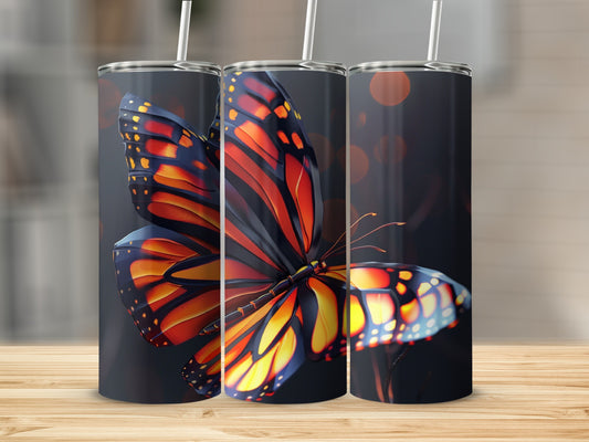 Three tall tumblers featuring a vibrant monarch butterfly design on a dark background.