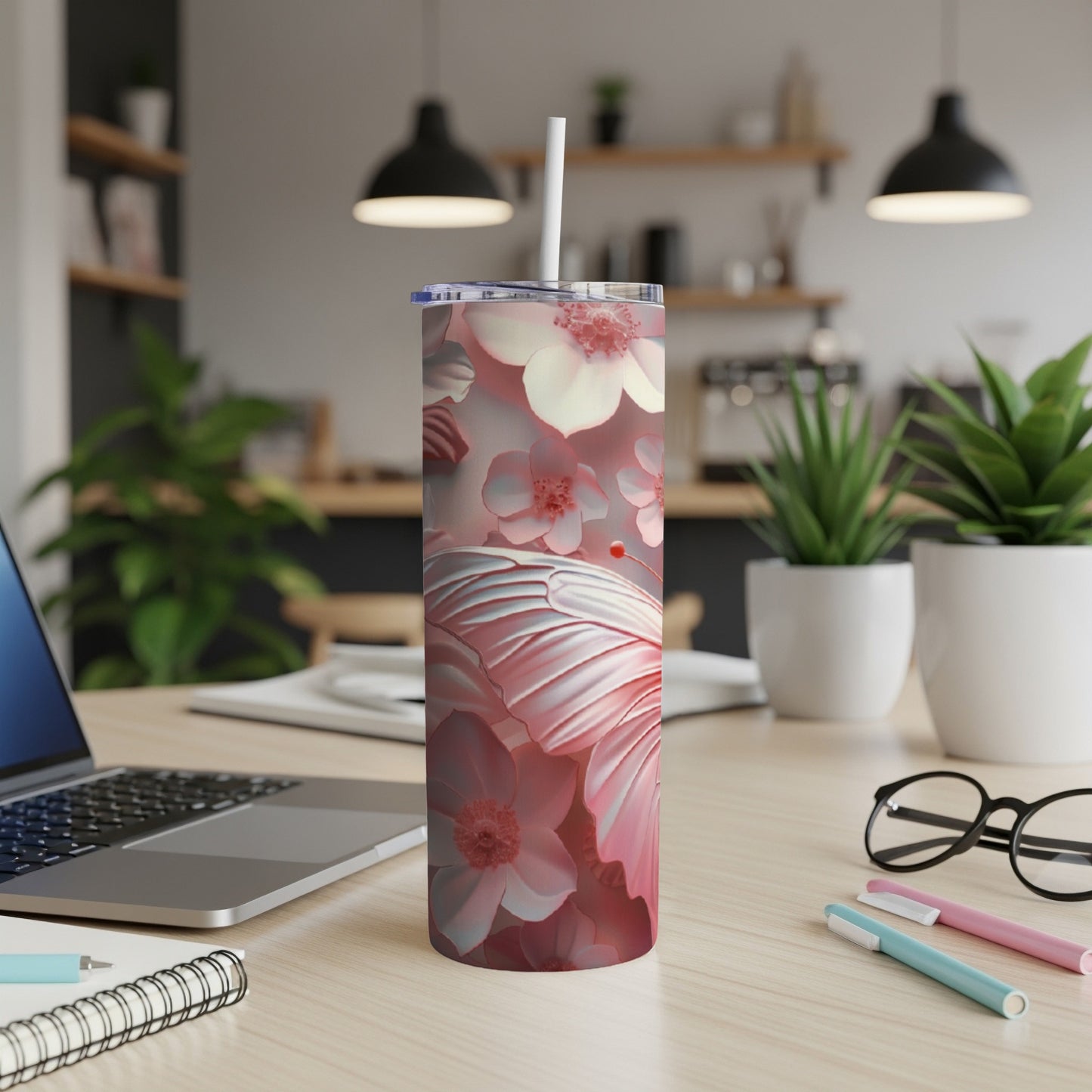 Pink floral butterfly tumbler with white lid and straw on desk.