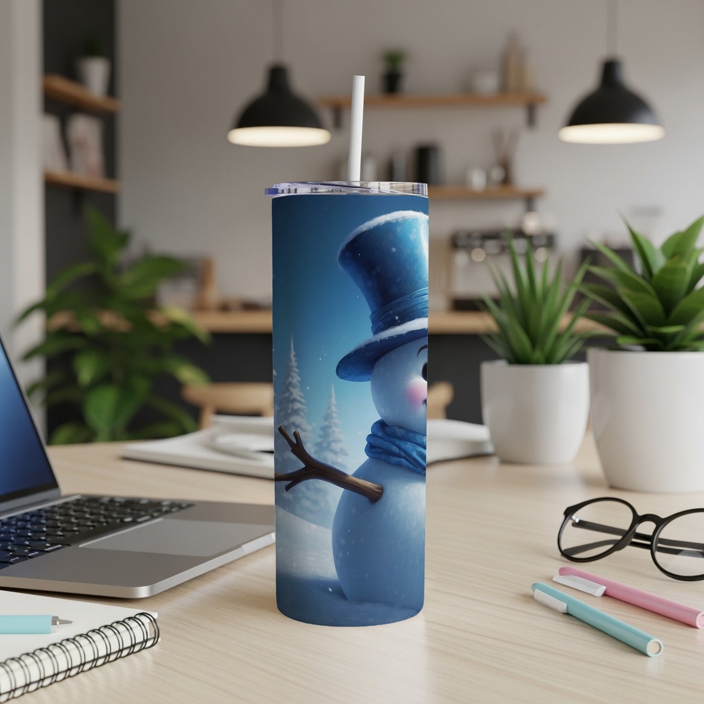 Snowman tumbler with blue hat and scarf, white straw in a kitchen setting.
