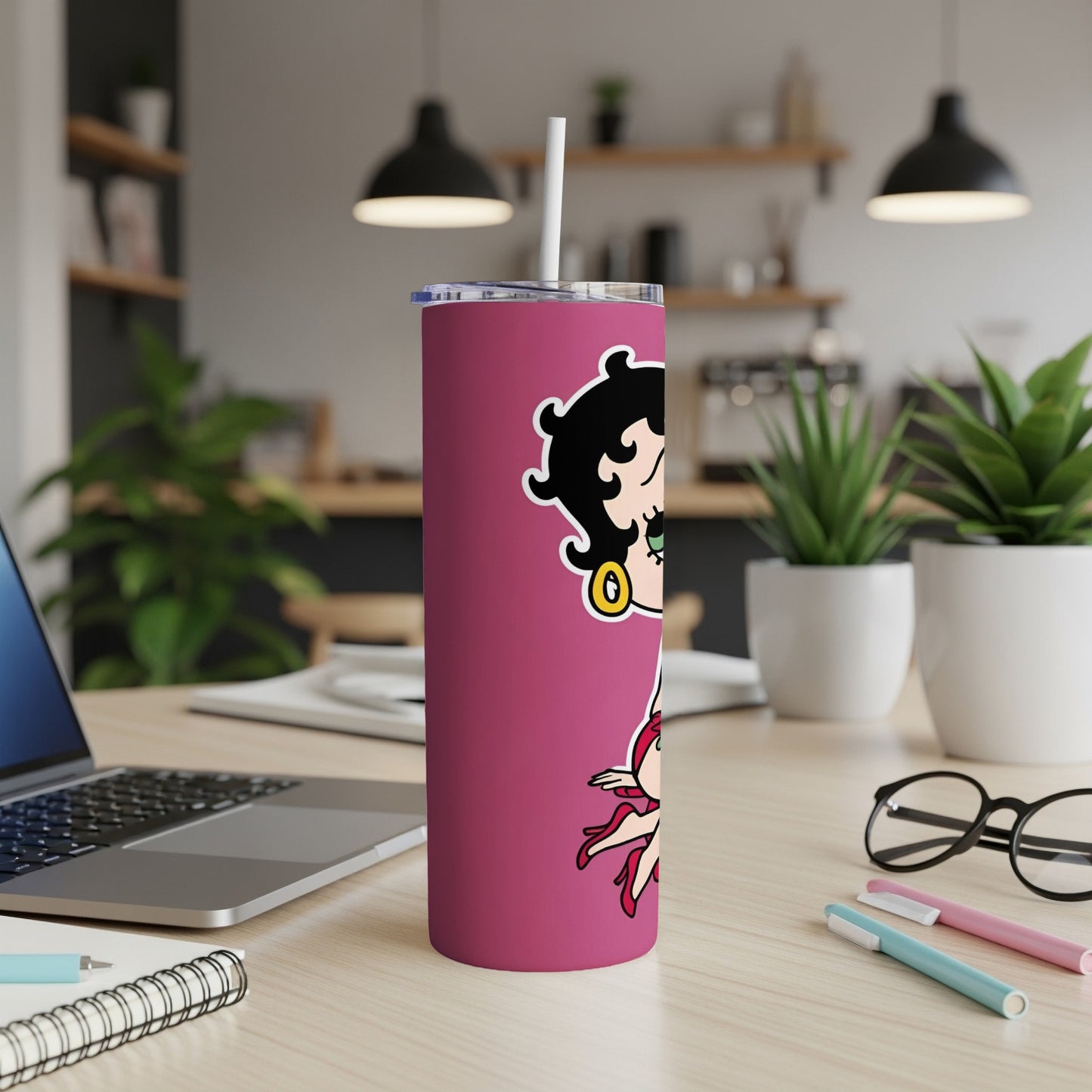Betty Boop tumbler with white straw on a desk.