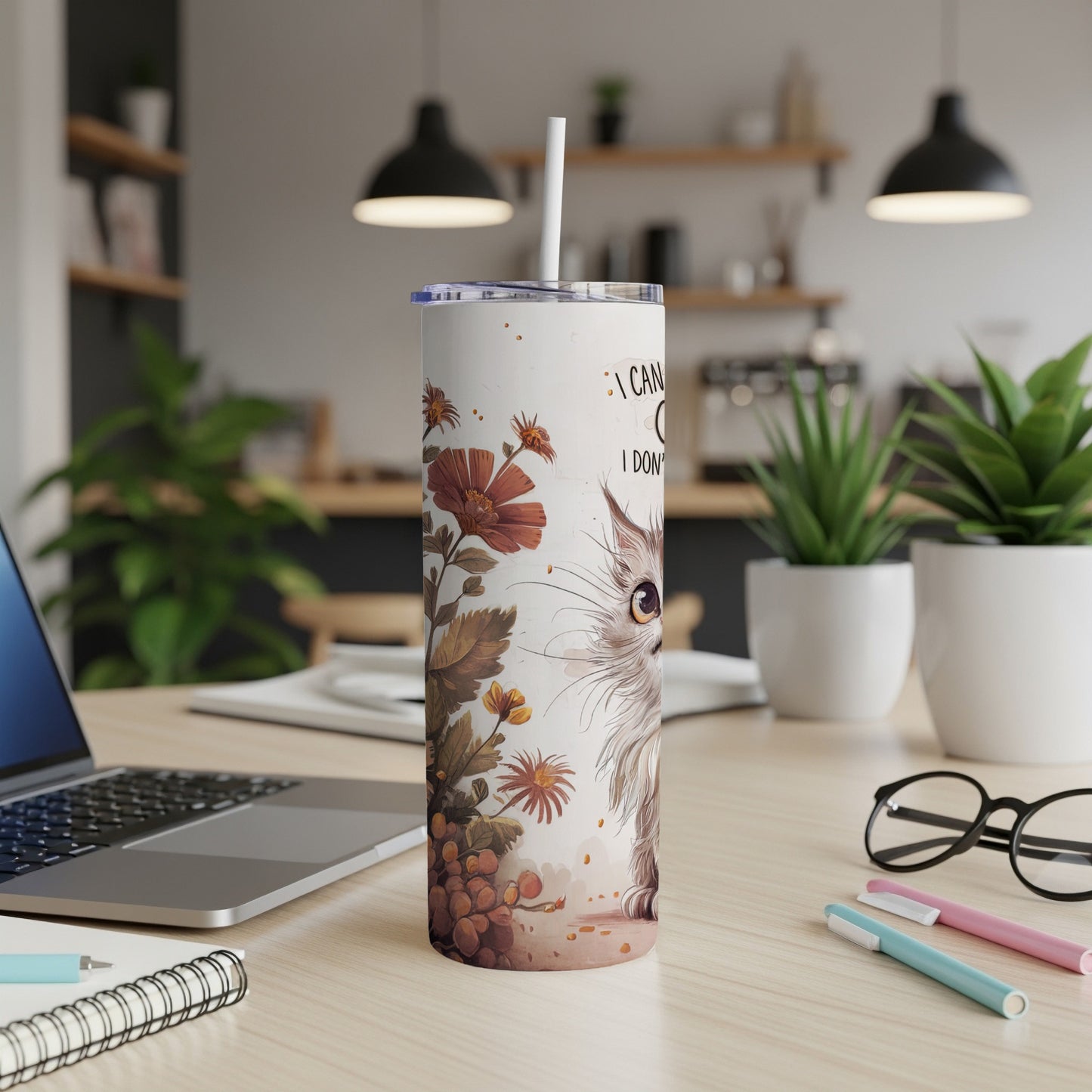 White tumbler with a cat illustration and text on a desk.