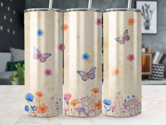 Three tumblers with a watercolor floral and butterfly design on a speckled cream background.