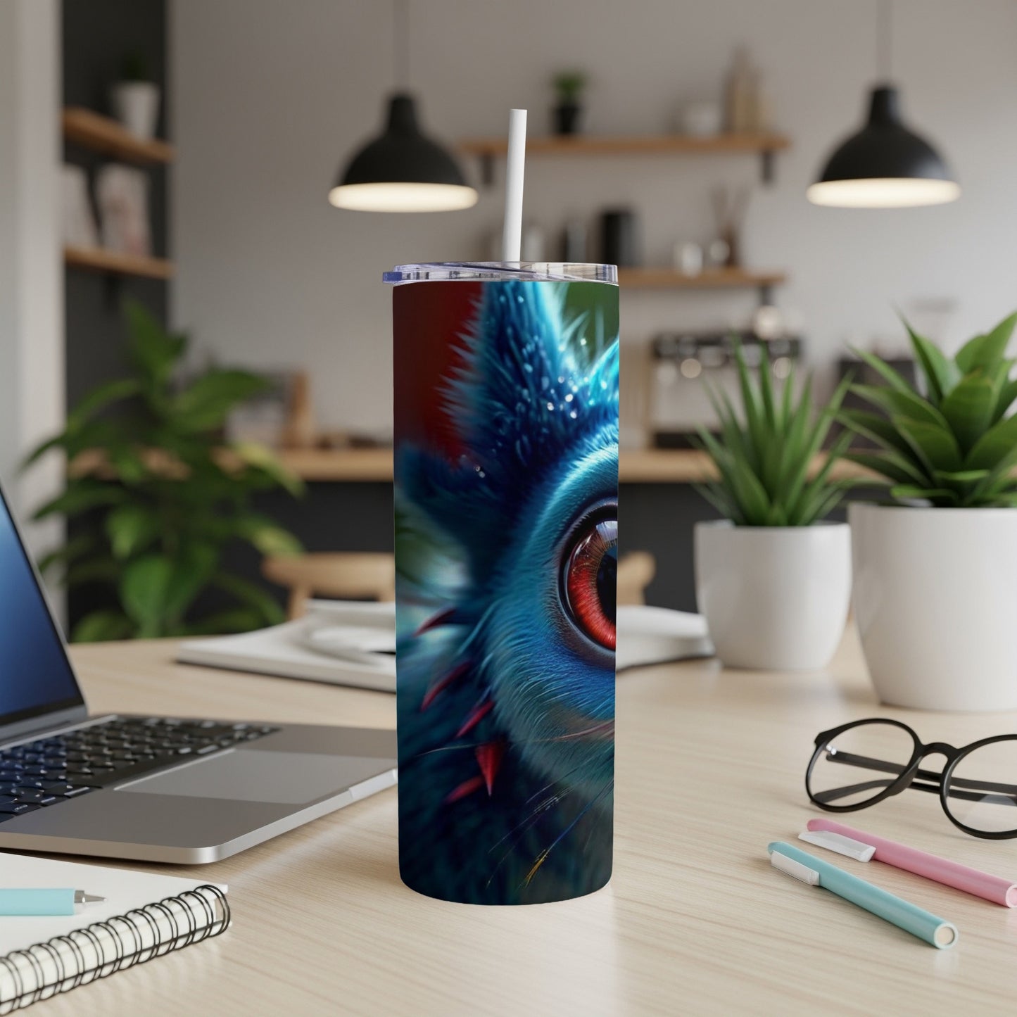 Blue creature with red eye on a skinny tumbler with straws and pens.