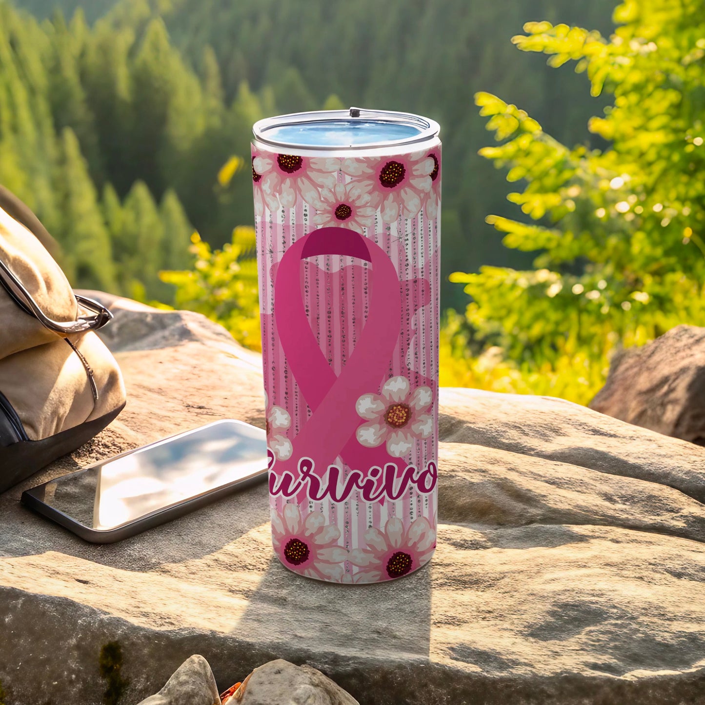 Pink ribbon tumbler with floral design and "Survivor" text on outdoor surface.