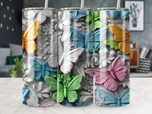 Three tumblers with colorful butterflies and floral embossed patterns.