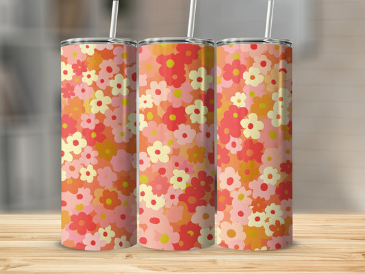 Three tumblers with a colorful floral pattern on a wooden surface.