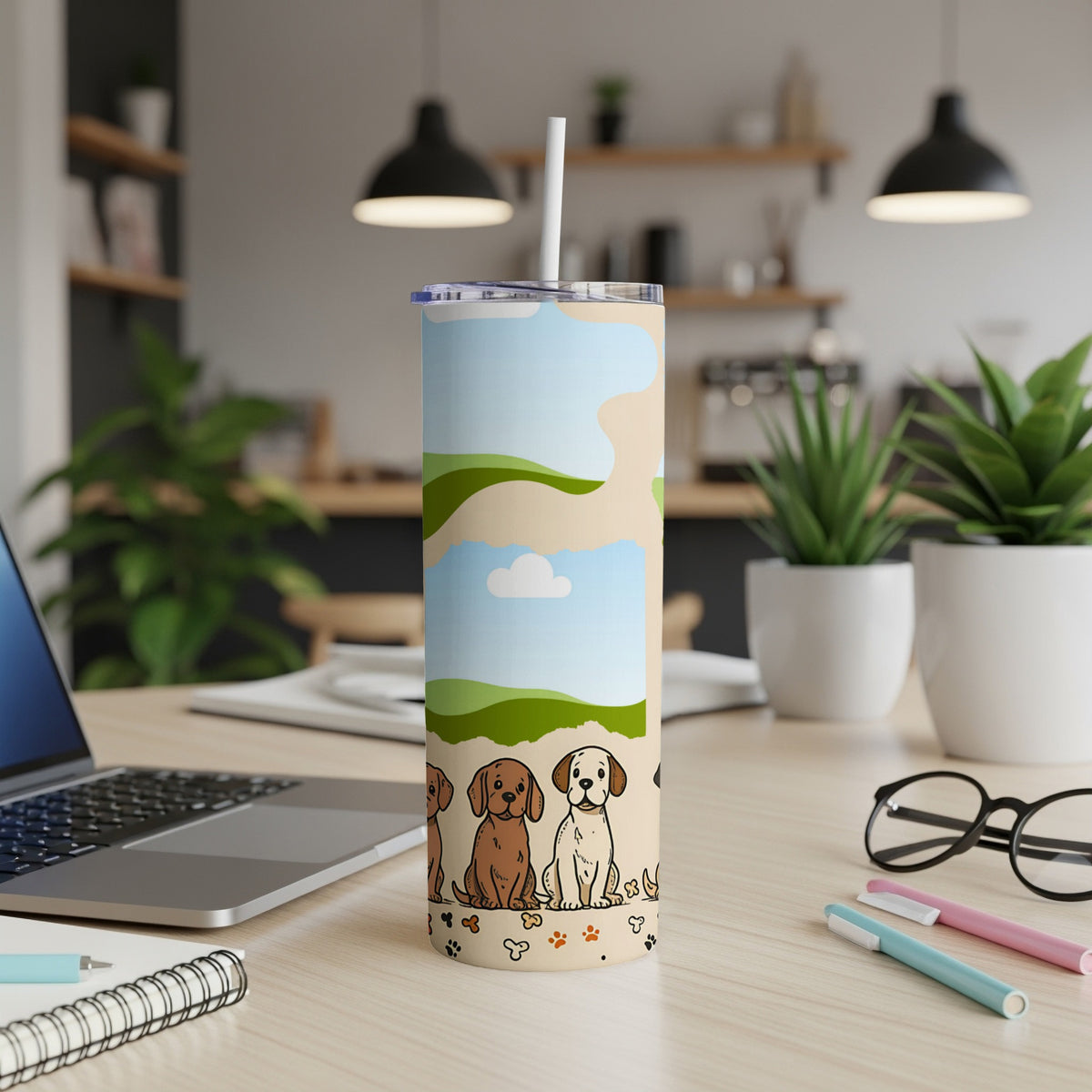 Tumbler with cartoon dogs and a landscape pattern, on a desk.