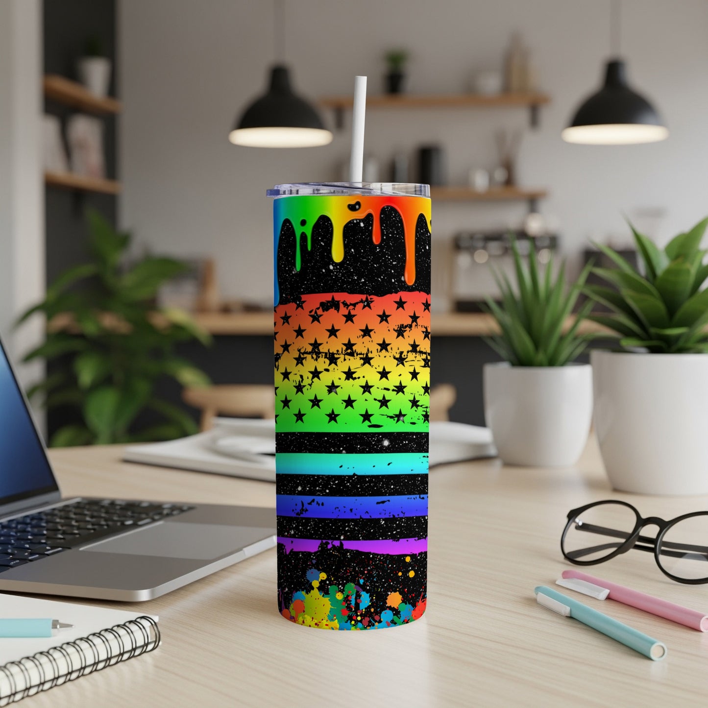 Rainbow splatter stars tumbler with straw on desk.