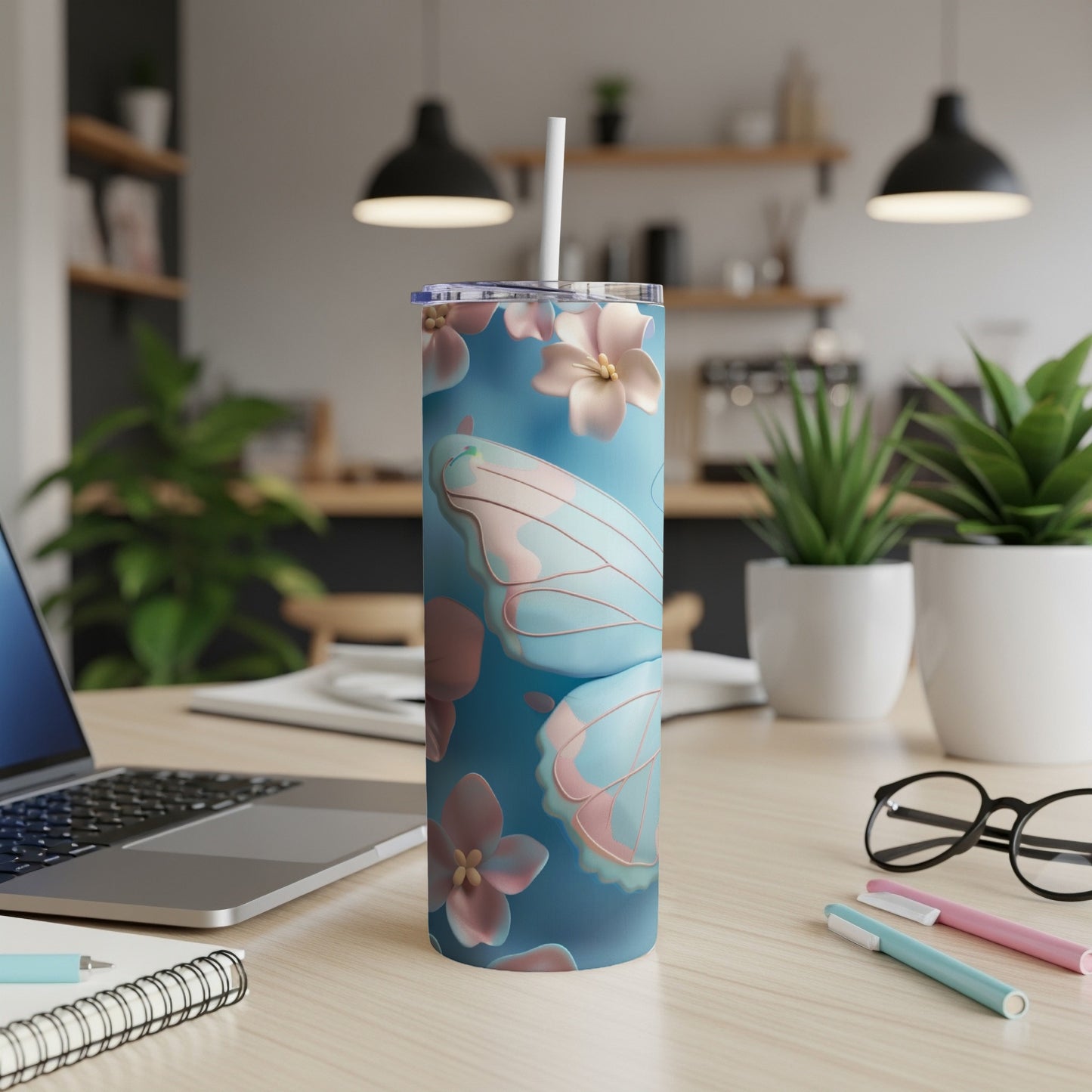 Blue tumbler with butterfly and floral pattern, straw in lid.