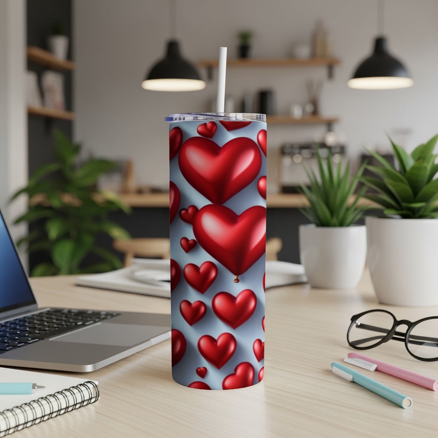 Red heart pattern on a silver skinny tumbler with a straw.