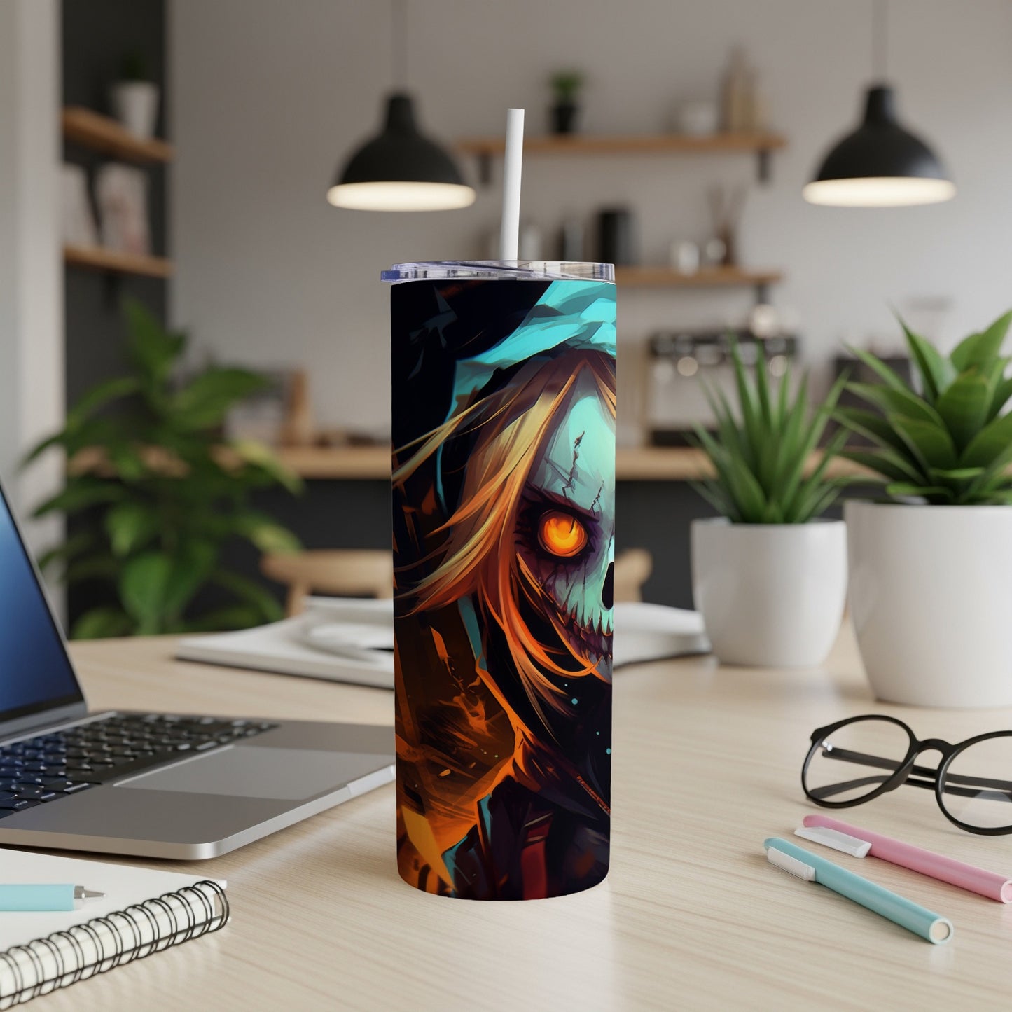 Tall tumbler with a skull and fiery hair design, shown on a desk.